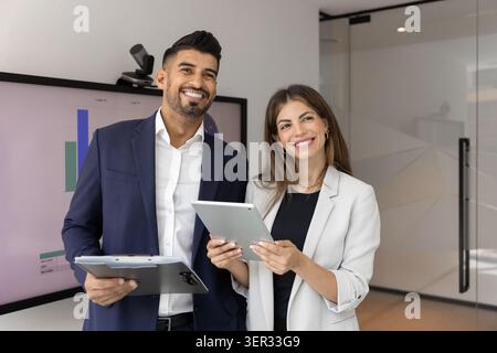 Teamkollegen halten Tablet und Klemmbrett mit Dokumenten im Büro Stockfoto