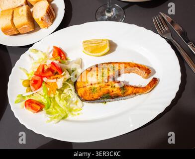 Lachssteak mit frischem Gemüsesalat auf Teller Stockfoto