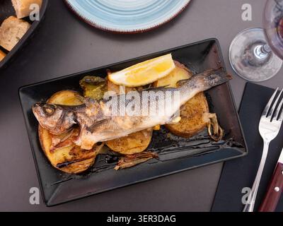Frischer Wolfsbarsch, gebacken mit Kräutern und Kartoffeln. Stockfoto