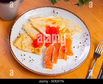 Dünne Pfannkuchen mit Kaviar und Lachs auf einem Teller Stockfoto