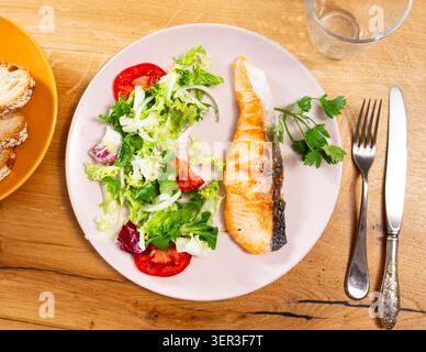 Lachssteak mit frischem Gemüsesalat auf Teller Stockfoto
