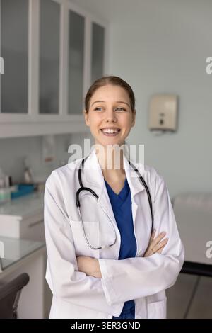 Lächelnde Ärztin steht in der Arztpraxis Stockfoto