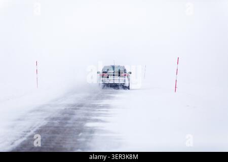 Auto fahren auf einer verschneiten Straße Stockfoto