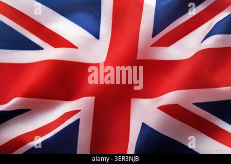 Britische Flagge mit Stoffstruktur, die im Windhintergrund winkt, Makroaufnahme Stockfoto