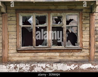 Foto eines Glasfensters eines alten zweistöckigen verlassenen Holzgebäudes, das für den Abriss vorgesehen ist Stockfoto
