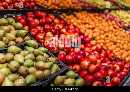 Farbenfrohe Auswahl an frischen Äpfeln und Birnen in der Lebensmittelabteilung des Supermarktes Stockfoto