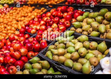 Frische Äpfel und Birnen werden im farbenfrohen Obstbereich des Supermarktes ausgestellt Stockfoto