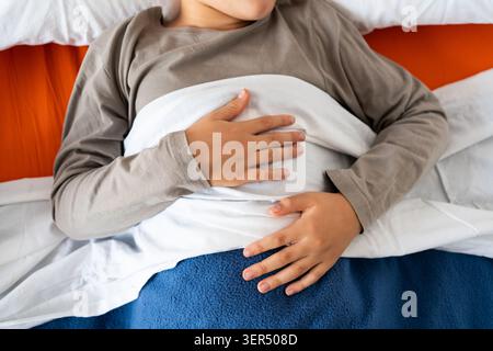Von oben aus der Ernte anonymer Mann im Pyjama, der im Bett unter warmer Decke liegt und schläft Stockfoto