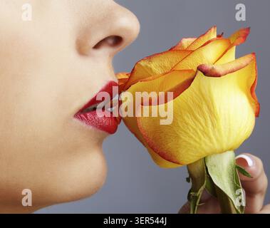 Nahaufnahme des unteren Teils des Mädchengesichts mit gelber Rose Stockfoto
