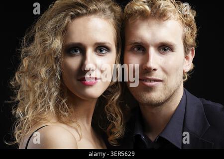 Nahporträt eines blonden Paares auf Schwarz Stockfoto