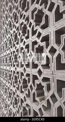 Islamisches geometrisches Muster an einer Wand mit unglaublicher Kunstfertigkeit, geeignet für islamische Designs, kulturelle Projekte oder künstlerische Hintergründe. Stockfoto