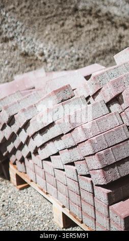 Rote Betonpflastersteine, die nahe auf dem Boden gestapelt sind. Stockfoto