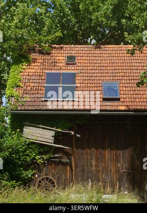 Alte bayerische Scheune mit Photovoltaikpaneel auf dem Fliesendach Stockfoto