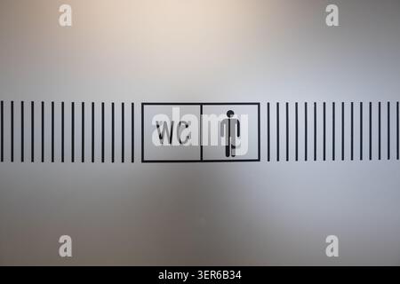 WC-Schild an der Glastür mit Hinweis auf öffentliche Toiletten Stockfoto
