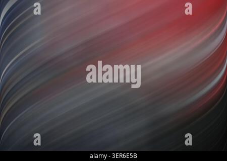 Ein abstrakter Hintergrund mit fließenden, diagonalen Linien, die Rot-, Grau- und Schwarztöne für einen dramatischen und stimmungsvollen Effekt kombinieren. Stockfoto