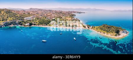 Das Küstenpanorama von Kusadasi zeigt die Insel- und Stadtgebäude entlang der türkisfarbenen Ägäis mit Booten auf dem Wasser Stockfoto