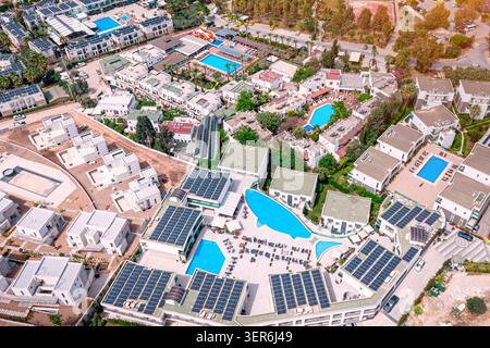Resortkomplex mit verschiedenen Gebäuden mit Solarpaneelen, mehreren Swimmingpools und Grünflächen für nachhaltige Urlauber Stockfoto