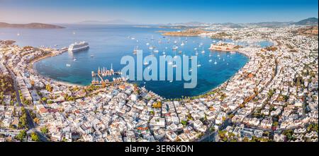 Aus der Vogelperspektive von Bodrum, Turkiye Küste mit einem geschäftigen Hafen mit zahlreichen Booten, die in der klaren Ägäis vor Anker liegen und von der Burg übersehen werden Stockfoto