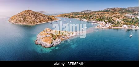 Gumusluk, Bodrum, genießt einen warmen Sommertag und zeigt Rabbit Island und private Yachten, die in der klaren türkisfarbenen Ägäis ankern Stockfoto