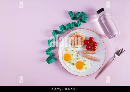 Spiegeleier mit Wurst, Kirschtomaten und Buchweizenbrot mit Lachsfisch Stockfoto
