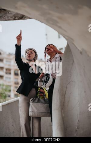 Geschäftsfrauen inspizieren eine städtische Baustelle und besprechen Architekturpläne während einer Standortbesichtigung Stockfoto