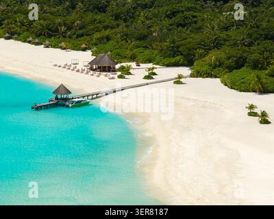 Blick aus der Vogelperspektive auf den Strand des maledivischen Resorts mit Steg und Pavillon Stockfoto