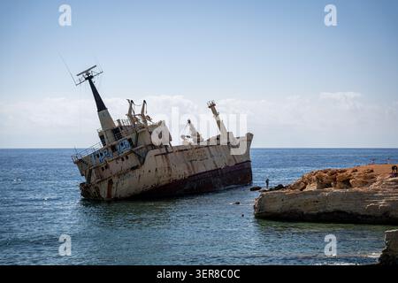 Blick auf das verrostete Schiffswrack Edro III, das auf seiner Seite in der Nähe der felsigen Küste unter einem klaren blauen Himmel im Mittelmeer Paphos, Paphos, Cypr geneigt ist Stockfoto