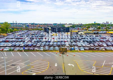New-York, USA - 7. April 2026: Hochwinkelblick auf einen riesigen Außenparkplatz mit Reihen geparkter Autos an einem sonnigen Tag Stockfoto