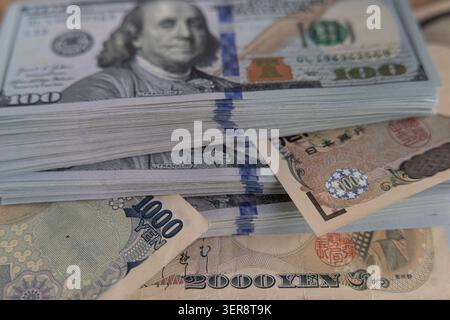 US-Dollar-Banknoten stapeln sich mit japanischen Yen-Scheinen aus nächster Nähe Stockfoto