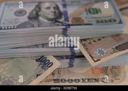 US-Dollar-Banknoten stapeln sich mit japanischen Yen-Scheinen aus nächster Nähe Stockfoto
