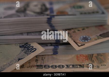 US-Dollar-Banknoten stapeln sich mit japanischen Yen-Scheinen aus nächster Nähe Stockfoto