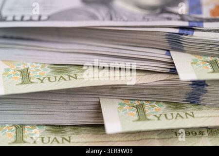 US-Dollar-Banknoten stapeln sich mit chinesischen Yuan-Scheinen aus nächster Nähe Stockfoto