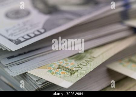 US-Dollar-Banknoten stapeln sich mit chinesischen Yuan-Scheinen aus nächster Nähe Stockfoto
