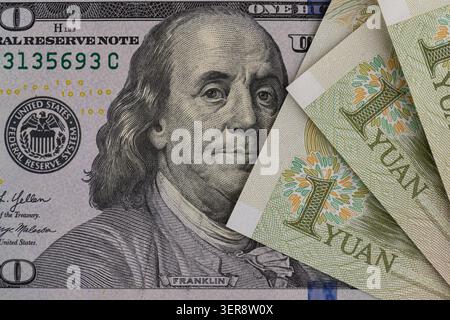 US-Dollar-Banknoten stapeln sich mit chinesischen Yuan-Scheinen aus nächster Nähe Stockfoto