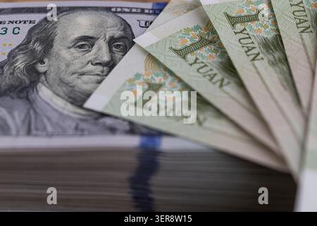 US-Dollar-Banknoten stapeln sich mit chinesischen Yuan-Scheinen aus nächster Nähe Stockfoto