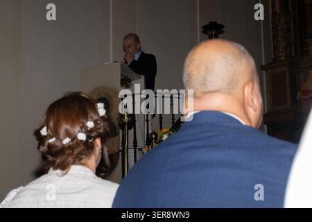 Leute hören einem Priester zu, der während eines Gottesdienstes von der Kanzel aus spricht Stockfoto