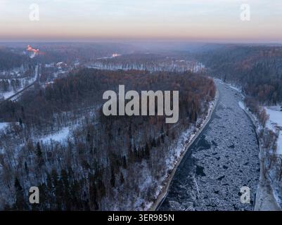 Aus der Vogelperspektive des Gauja-Flusses, der sich durch verschneite Waldlandschaft in der Nähe von Turaida im Gauja-Nationalpark in Lettland schlängelt Stockfoto