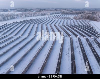 Luftaufnahme eines großen, im Winter mit Schnee bedeckten Solarparks in der Nähe von Sigulda, Lettland Stockfoto