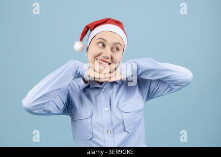 Frau lächelt und posiert mit den Händen nahe dem Gesicht Stockfoto