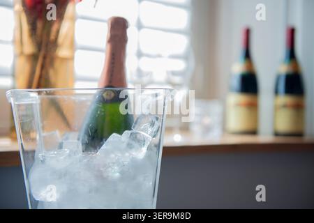 Gekühlter Champagner bereit zur Feier in einem gemütlichen, sonnendurchfluteten Raum mit eleganter Einrichtung Stockfoto