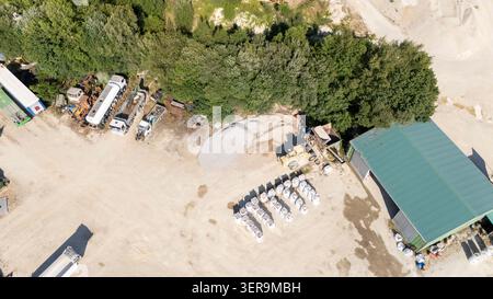 Luftaufnahme mit Zuschlagshäueln, Industriegebäuden, schweren Maschinen und Transportfahrzeugen in einem Steinbruch in Sandias, Galicien, Spanien Stockfoto