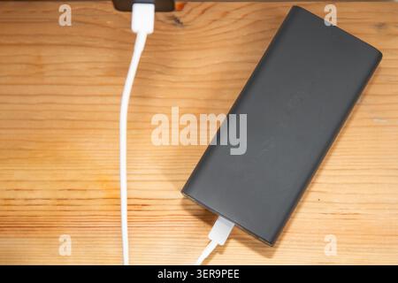 Tragbare Powerbank mit USB-Ladeanschlüssen und angeschlossenem Ladekabel Stockfoto