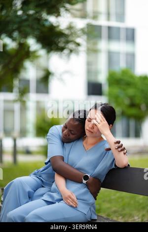 Mitarbeiter des Gesundheitswesens trösten Teammitglied mit Stress Burnout Stockfoto