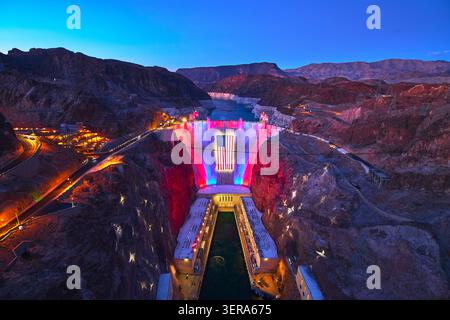 Hoover Dam Nevada beleuchtet mit amerikanischer Flagge und rot-weiß-blauen Lichtern bei Nacht Stockfoto