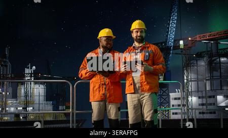 Porträt von lächelnden Besatzungsmitgliedern der Bohrkahn, die während der Ölkrise Benzinreserven verwalten. Glückliches Offshore-Rig-Team, das Geräte zur Überwachung der Operationen während des Embargos für die Seeverkehr verwendet, Kamera A Stockfoto