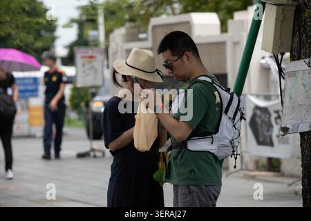 BANGKOK, THAILAND - 30. MAI 2026: Touristenpaar auf Smartphone, Seitenprofil. Stockfoto