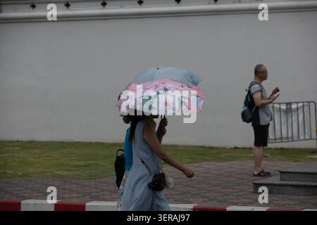Weibliche Touristen, die mit Sonnenschirmen laufen, die Stadt erkunden, Seitenprofil. Stockfoto