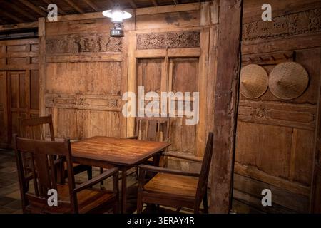 Ein Sessel mit Teakholzmöbeln und einer alten Lampe zum Entspannen und Genießen von Speisen und Getränken am Nachmittag. Stockfoto