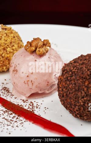 Drei Kugeln Eis-Desserts mit Walnüssen und Schokolade dekoriert Stockfoto
