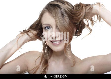 Das Porträt des schönen Mädchenmodells berührt ihr langes Haar Stockfoto